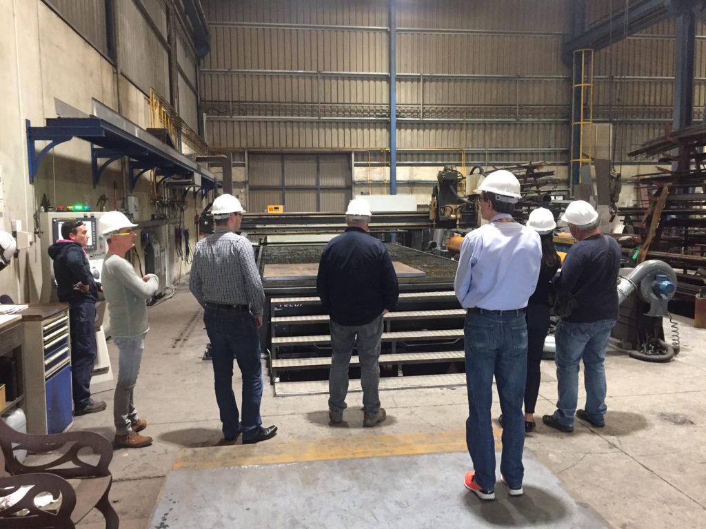 Foto de todos los integrantes de la visita delante de las instalaciones de Talleres Mecánicos Galicia