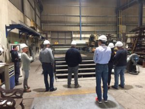 Foto de todos los integrantes de la visita delante de las instalaciones de Talleres Mecánicos Galicia